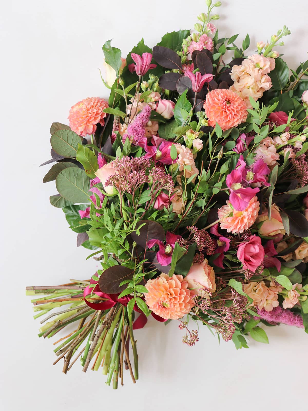 Funeral Sheaf of flowers with pink, orange, and green colors on a white background
